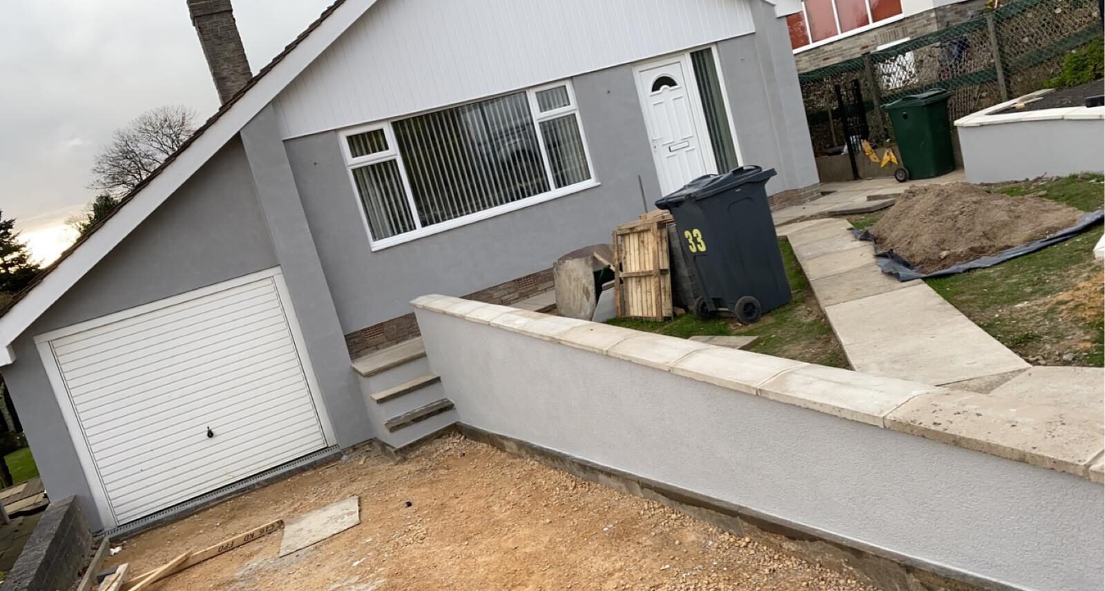 Grey rendered elevation with steps and rendered retaining wall